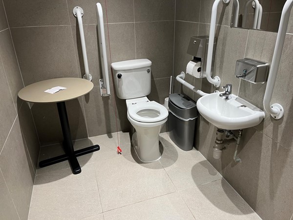 Accessible toilet with the table added that doesn’t get in the way of accessing or transferring onto the toilet. Plenty of room for a carer in here.