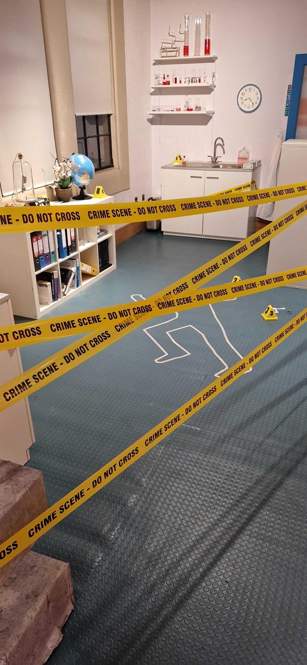 Crime Scene investigation activity at Edinburgh Science Festival - a fake crime scene in a lab with a body chalk outline on the floor.
