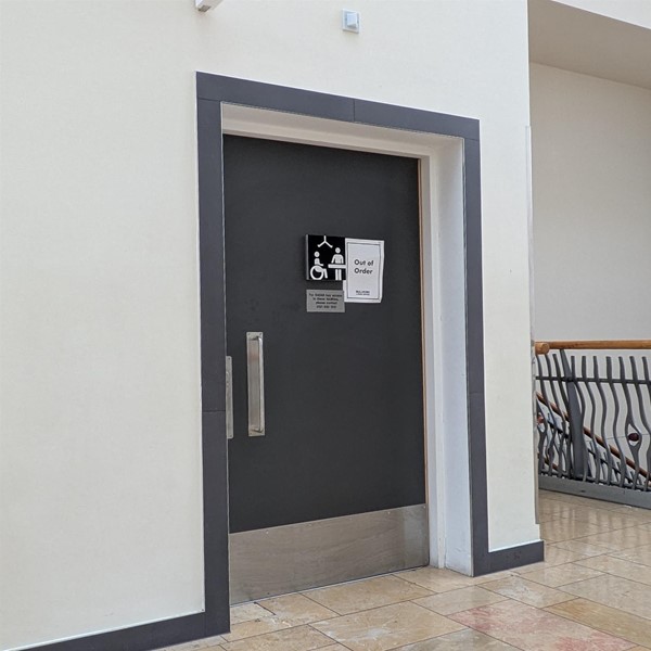 Image of door to Changing Places toilet - a sign states the toilet is out of order