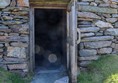 Door to the longhouse with stone blocking the path.