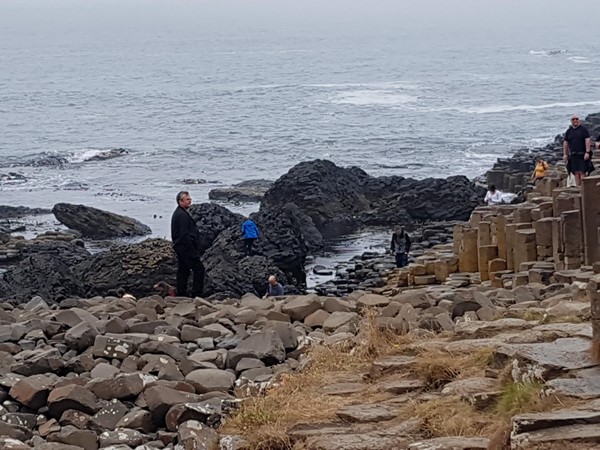 The rocks of the Giant's Causeway. You can get pretty close in a wheelchair or scooter but not down to where you can see the people climbing