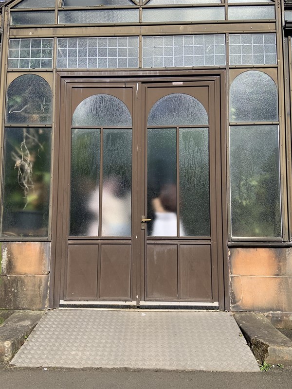 image of large double doors with frosted windows and a metal ramp leading up to them