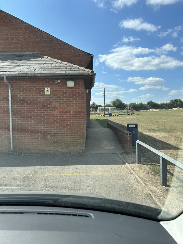 View of the Village Hall, parking from a car
