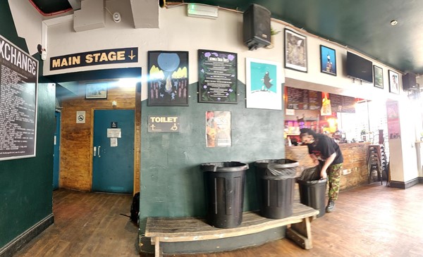 Picture of entrance space inside. This is the view you would have when entering the entrance on the side of the building. On the right is a bar, straight onwards is the disabled toilet. On the left are two entrances to two stages, the main stage is through a set of double doors on the left of the toilet.