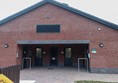 Entrance area to the facilities block, with wide open paved surface.