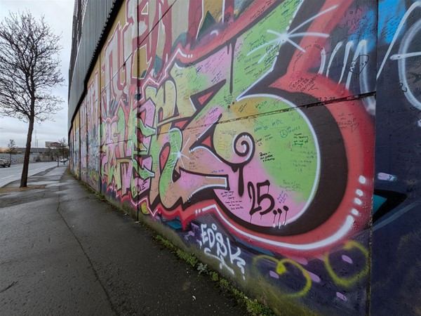 Image of mural on wall - pink and green letters