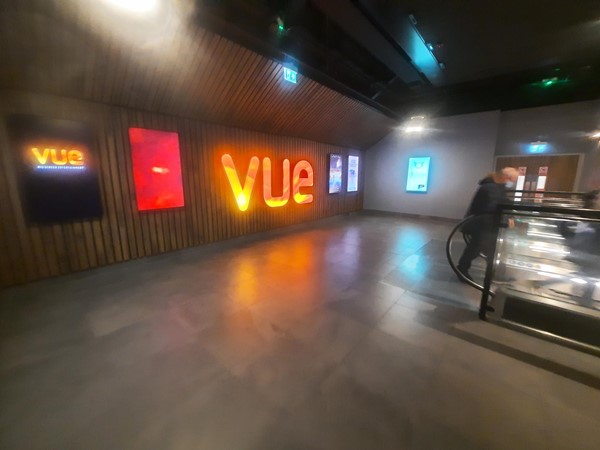 Picture of Vue cinema logo on a wall and an escalator