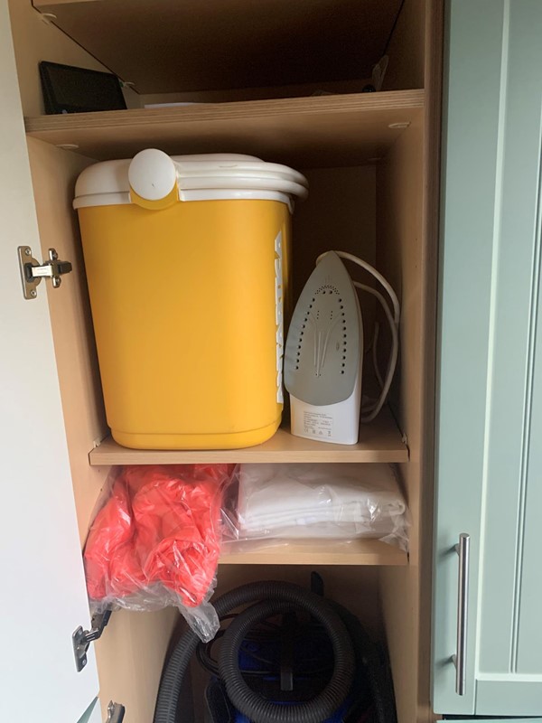Yellow container and iron on a shelf