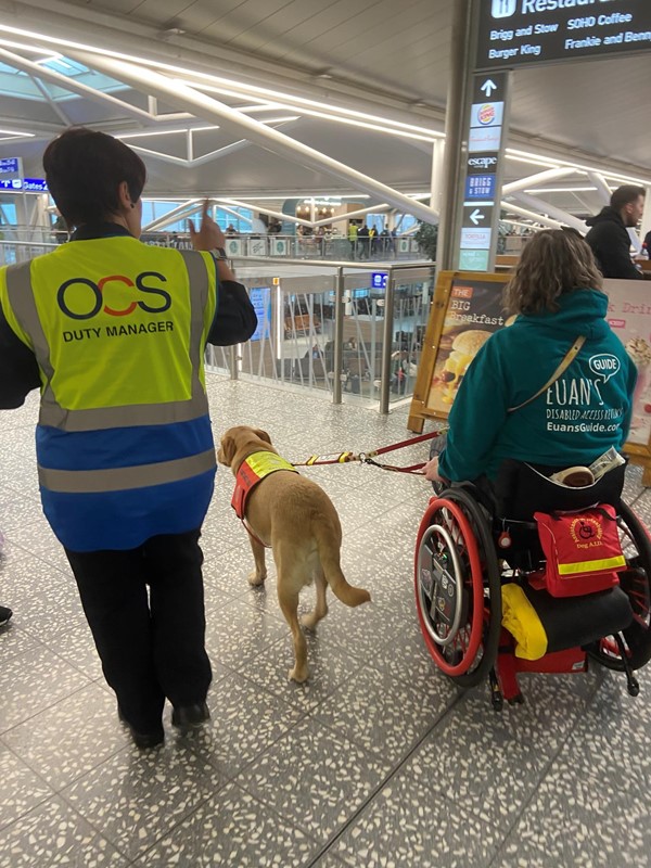 Image of a wheelchair user, duty manager and an assistance dog at Bristol Airport