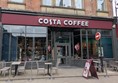 Image of exterior of Costa Coffee, white letters on a red background show the name of the location.