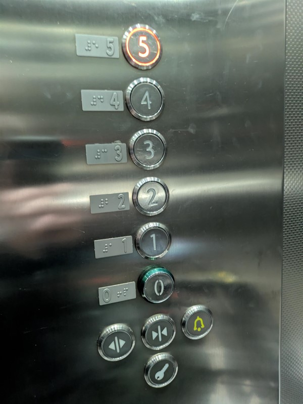 Image of lift buttons. The lift buttons have braille markings