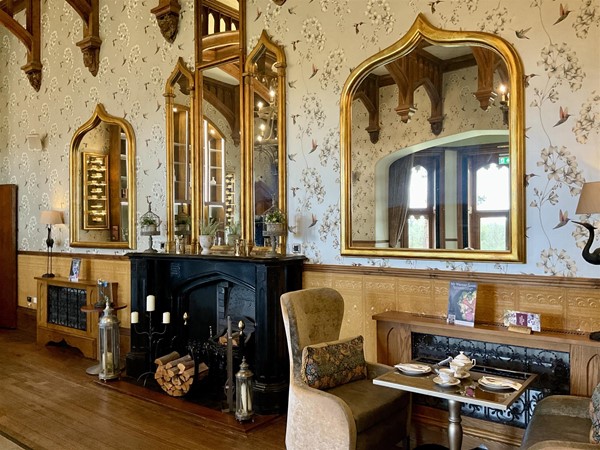 “THE OAK ROOM” One of the three original lounges of the old castle, beautifully restored, in this old Victorian mansion. It still has its historical charm, now mixed with modern facilities. This is one of the popular rooms of the old part of the castle, with its delightful wooden beams, picture frames of golden furnished frames. The cups on display add a real charm to the room. It’s a pleasant place to relax in, the drinks are very well made, and of course it’s here you enjoy any afternoon tea you have pre-booked. The chairs are reasonably comfortable, and the view through the windows towards the grounds offer the charm of the fresh green grass and shrubbery that helps the body and mind to unwind.