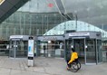 Paul wheels toward the automatic doors at the main entrance of Dundee railway station