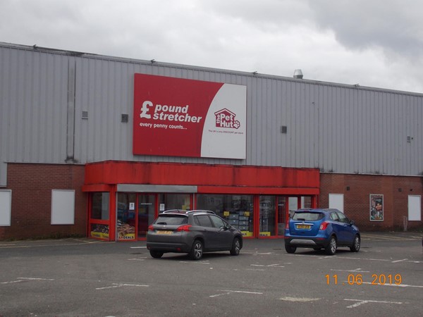 This photo shows the Car park and main doors in to the store. There is one Blue Badge space on the Left hand side of the door. however it is very close to the wall.