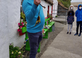 Famine Village guide giving demonstrations of local food and customs outside the traditional house where he lived as a child. You can see the ramp up to the accessible toilet at the back of the picture