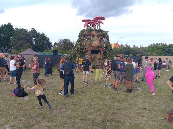 Image of people and a giant sculpted head