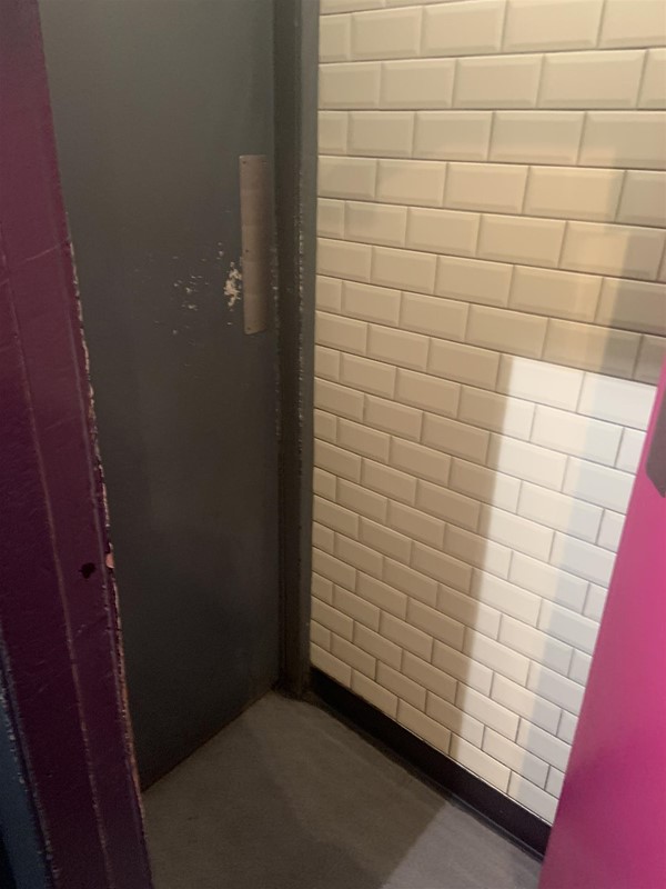 Image of the edge of a door and a tiled wall