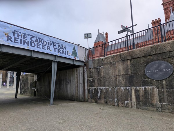 Image of a grey plaque on a brick wall with the writing Roald Dahl Plass