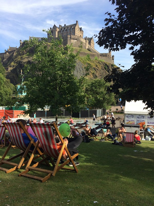 Photo of deck chairs in West Princes Street Gardens beneath the castle.