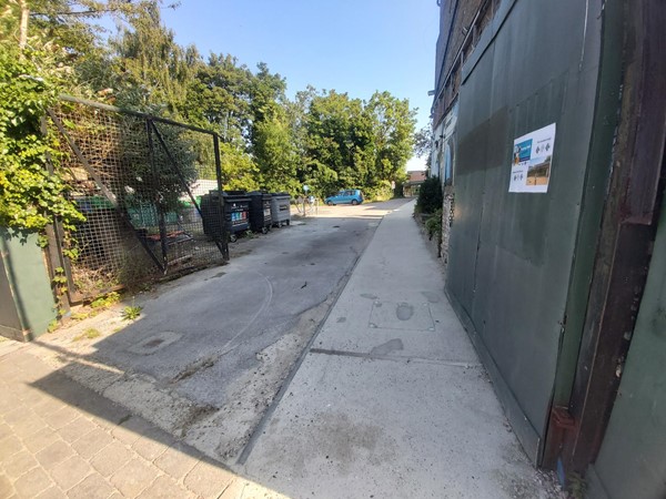 Concret path between a building and some bins