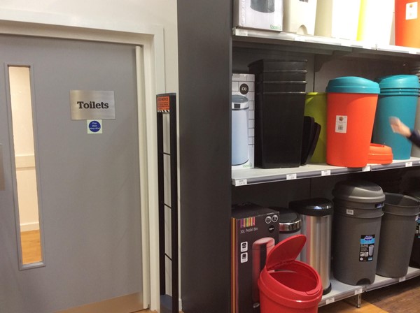 Removing a wall and using this space, currently occupied by bins for sale, would provide ample space for a Changing Places toilet.