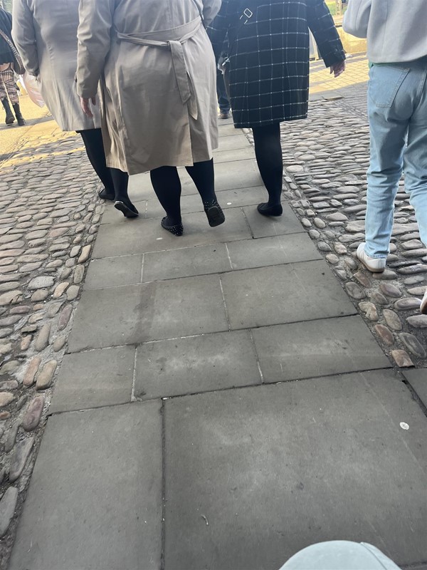 Image of the lower half of people on a path.