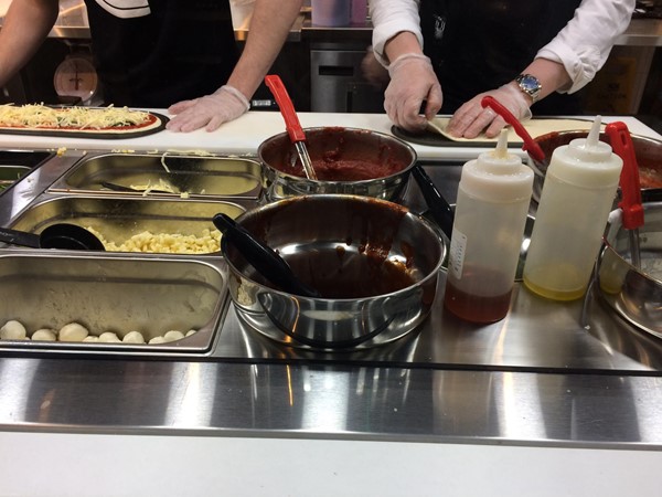 Photo of pizza being made.