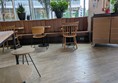 Image of wooden seats and a long leather bench along the wall, there are power sockets beneath the benches