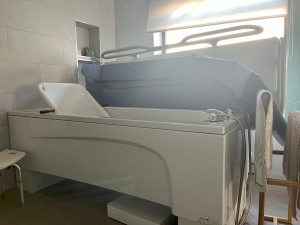 Image of the bath and shower trolley in the accessible bathroom.