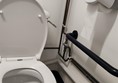 Image of the toilet with the flusher handle on the side close to the wall meaning it is difficult for someone using a wheelchair, balance issues or shorter reach distance to flush the toilet