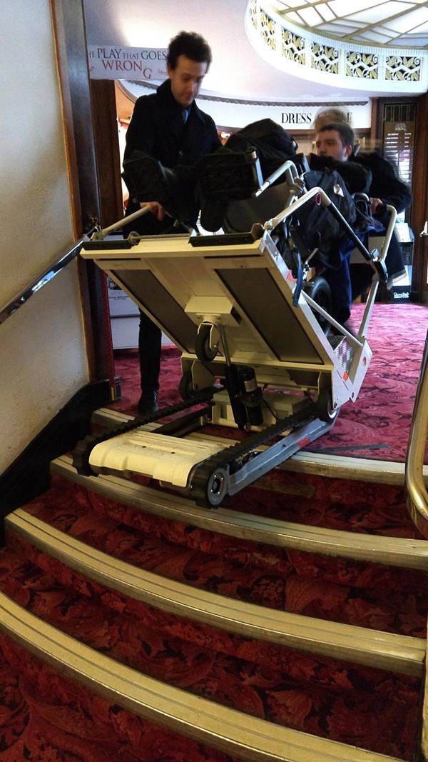 Stair climber being used. The figure in the chair is me and the staff pictured have given consent to use all attached photos