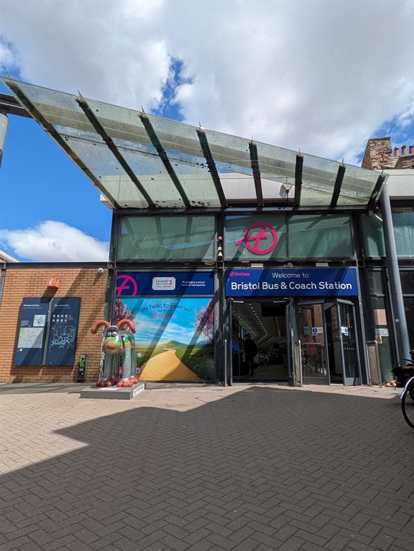 Image of entrance to Bristol Bus & Coach station, there is a Wizard of Oz themed Gromit statue outside