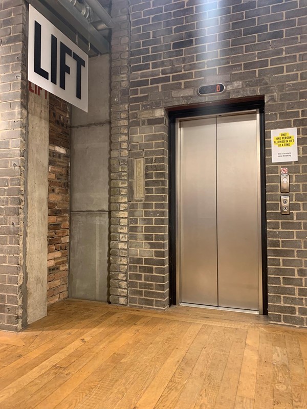Sign for Lift next to the small lift at the back of the store