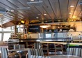 Inside the Mariners Cafe with open servery area and tables and chairs around it.