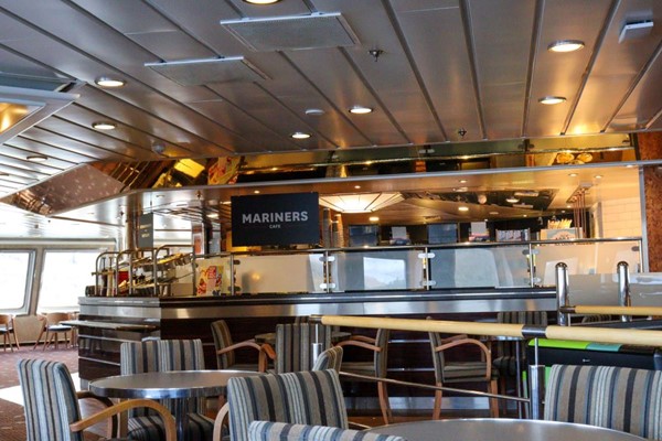 Inside the Mariners Cafe with open servery area and tables and chairs around it.