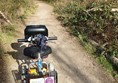 Image of a lightweight mobility scooter on a pathway in a forest.