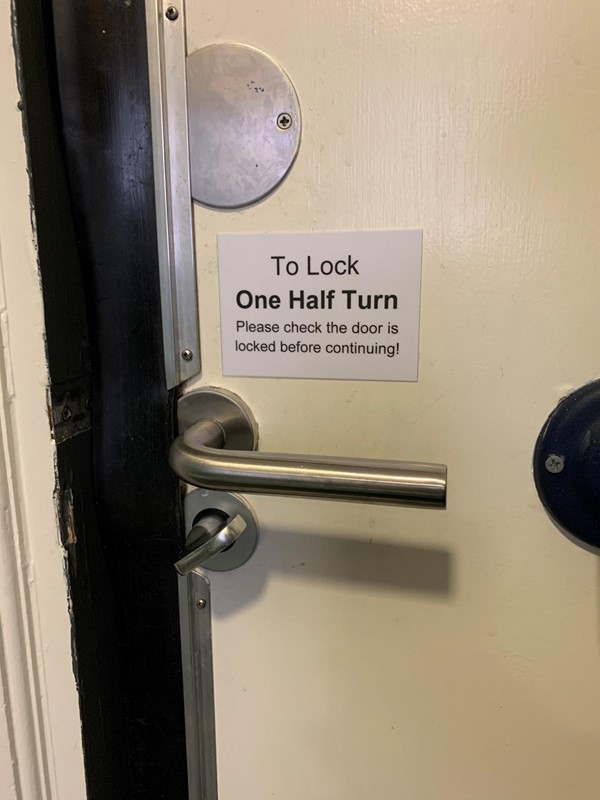 Note on bathroom door reminding people to check door is locked