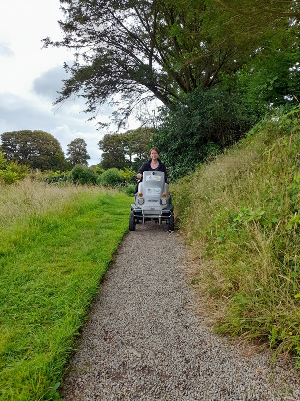 Myself on the sturdy National Trust Tramper, riding on a gravel footpath alongside a meadow.