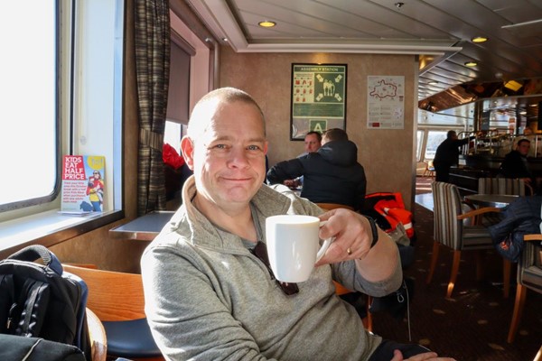 Man sitting in cafe enjoying a cup of coffee.