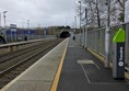 Image of the vacant platform, showing signage and tactile paving at the edge.