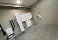 Inside the Changing Places toilet, showing the adult sized changing bench and the adjacent shower unit