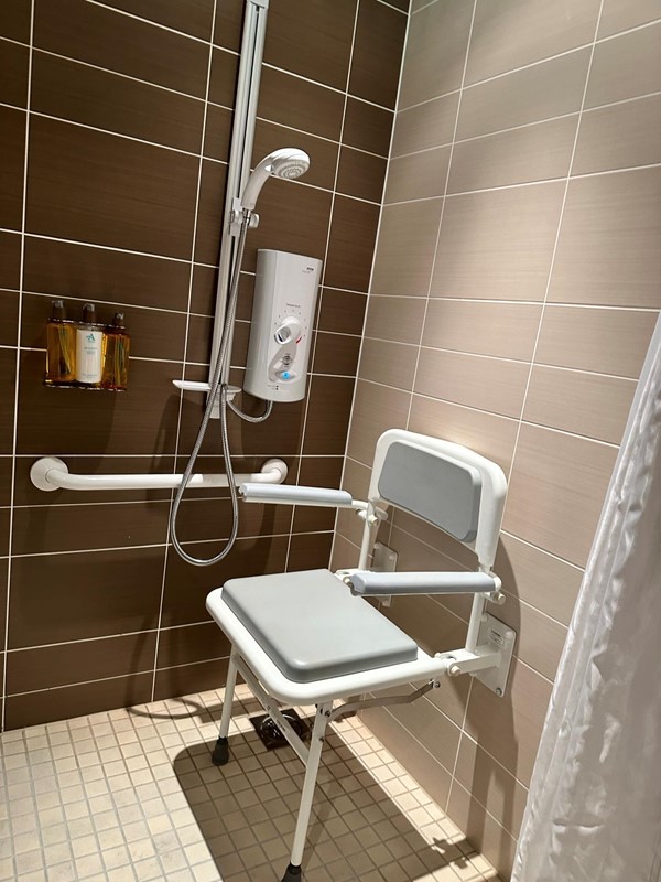 The shower and chair in the accessible bathroom.