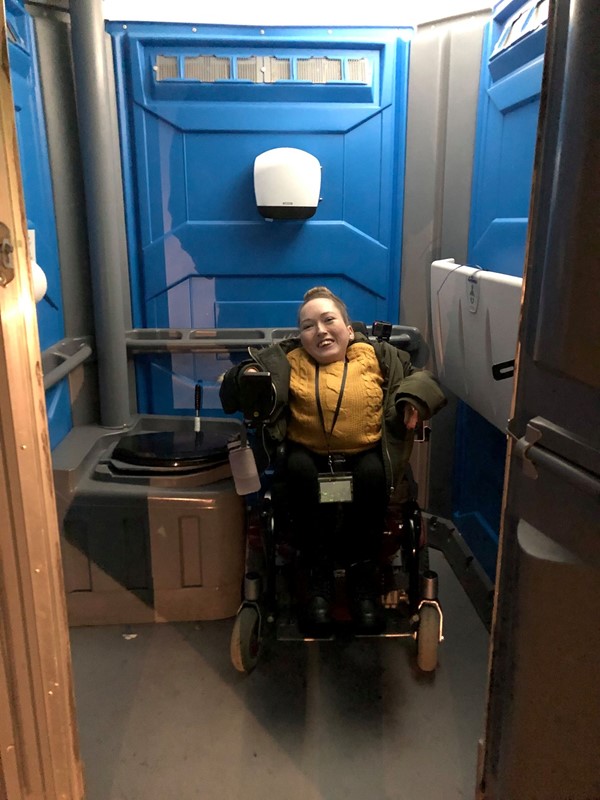 Image showing Claire in the accessible portacabin toilets in her wheelchair.