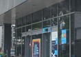 Exterior of shop. The green/red light is above the entrance door. Shopping trolleys are on the right hand side of the door.