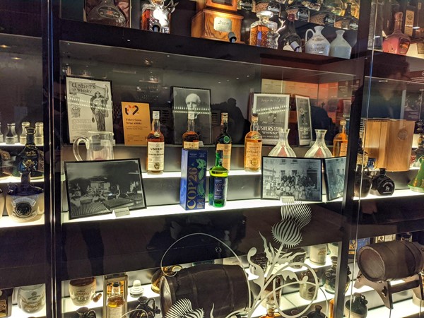 A cabinet of whisky and memorabilia with the COP26 blended whisky in the middle.