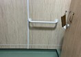 Image of a grab rail and a  door with a key in the lock