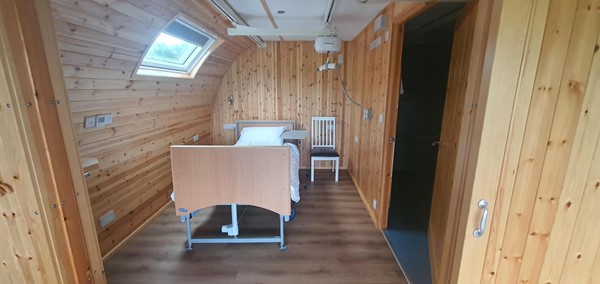 \Image of the bedroom in the accessible glamping pod including the profiling bed and tracking hoist.