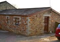 Front door to cottage with parking and small ramp.