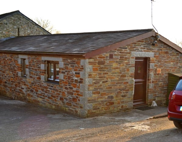 Front door to cottage with parking and small ramp.