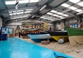 Inside, there is a bright blue path around the edge of the hall. In the middle are several boats.